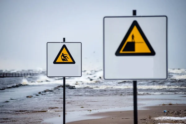 attention signs near sea with stormy weather