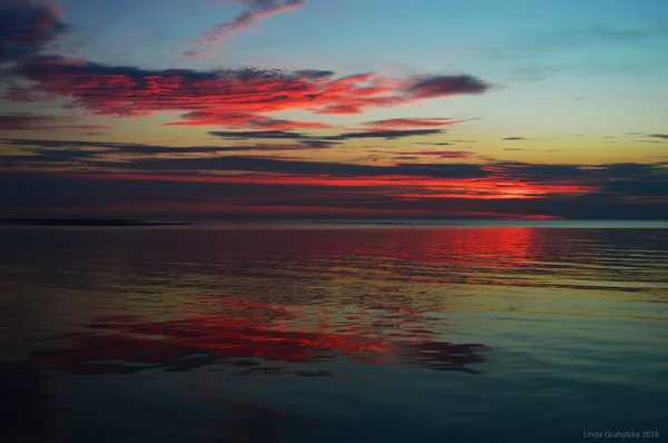 Colorful sunset in the sea with reflections and clouds — Stock Photo, Image