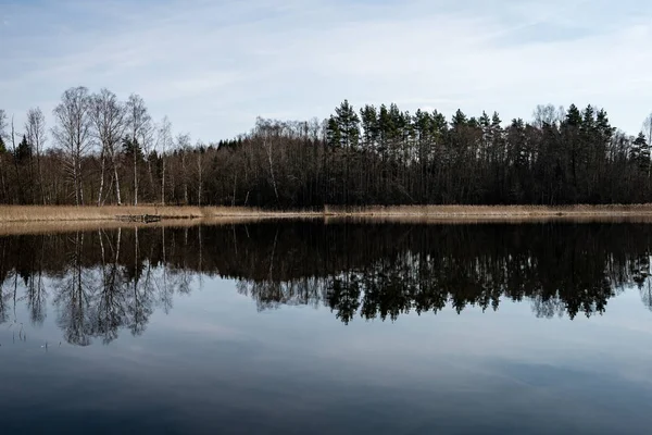 Отражение облаков в озере с набережной — стоковое фото