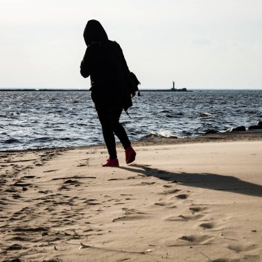 Anonim kişi bir kum rüzgarlı Sahilde yürürken