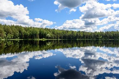 Beyaz bulutların üzerinde orman göl üzerinde mavi gökyüzü
