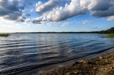 Günbatımında bir kayalık sahil plaj görünümünü