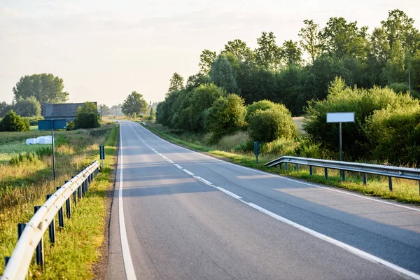 Carretera de campo con rayos de sol en la mañana — Foto de Stock