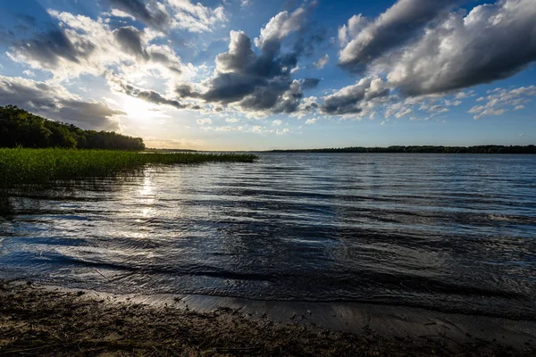 Günbatımında bir kayalık sahil plaj görünümünü