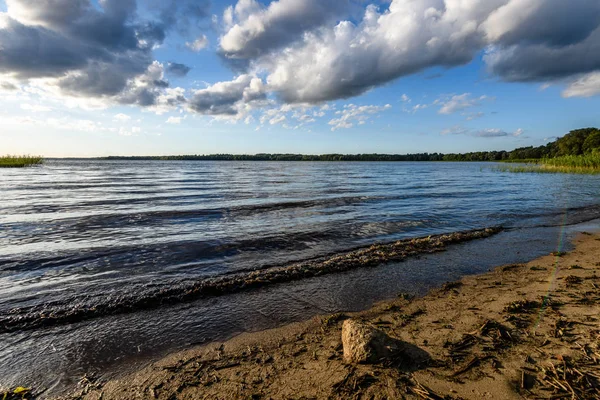Günbatımında bir kayalık sahil plaj görünümünü