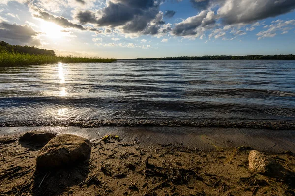 Günbatımında bir kayalık sahil plaj görünümünü