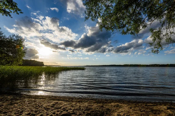 Günbatımında bir kayalık sahil plaj görünümünü