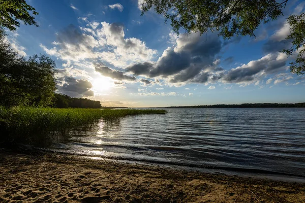 Günbatımında bir kayalık sahil plaj görünümünü