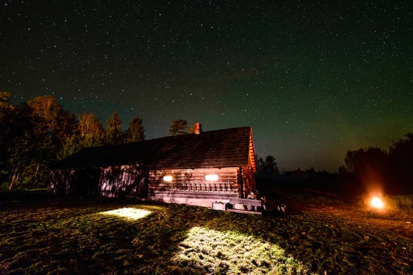 La Vía Láctea en el cielo nocturno con estrellas sobre casa de campo de madera — Foto de Stock