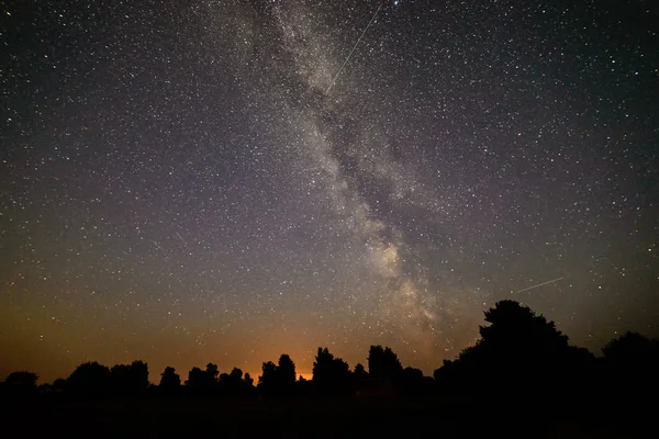 Bunte Milchstraßengalaxie am Nachthimmel über Bäumen — Stockfoto