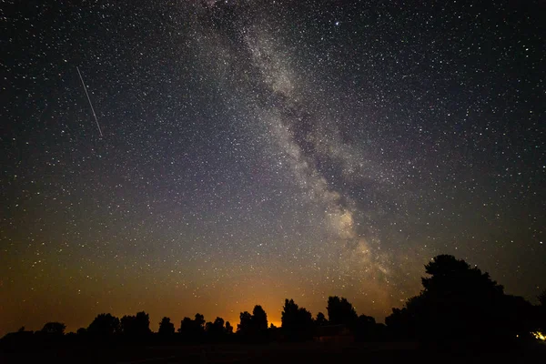 Colorida galaxia de la Vía Láctea vista en el cielo nocturno sobre árboles — Foto de Stock