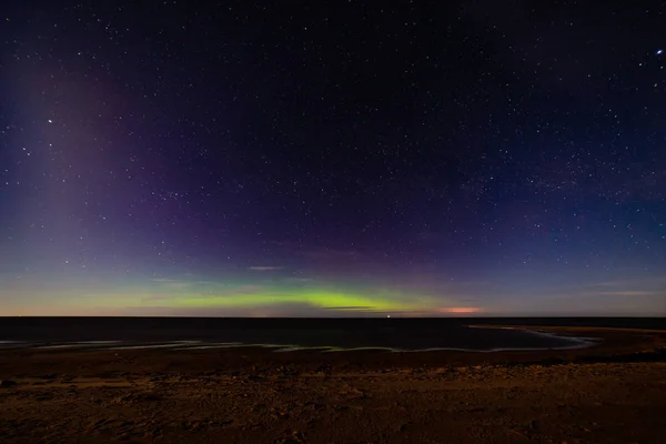 Intense northern lights aurora borealis over beach — Stock Photo, Image
