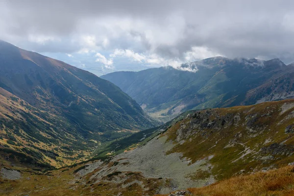 Cumbres de montaña en otoño cubiertas de niebla o nubes —  Fotos de Stock