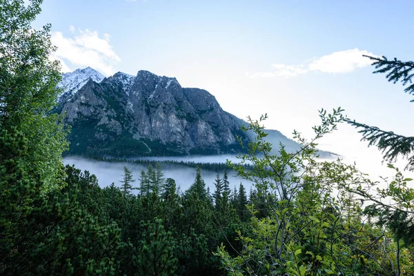 Bergstopparna i höst täckt i dimma eller moln i soliga dag — Stockfoto