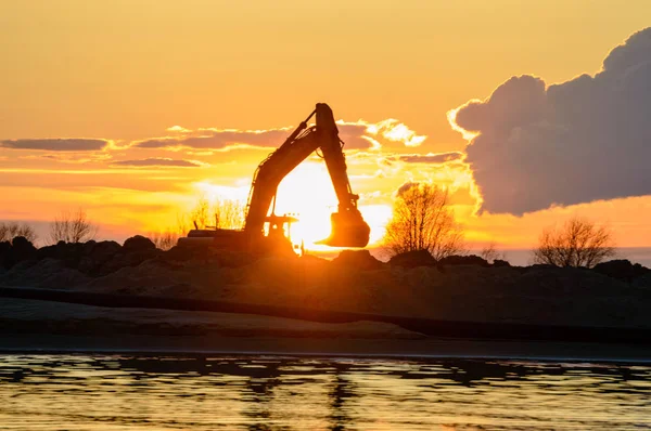Konstruktion kran i solnedgången vid havet — Stockfoto