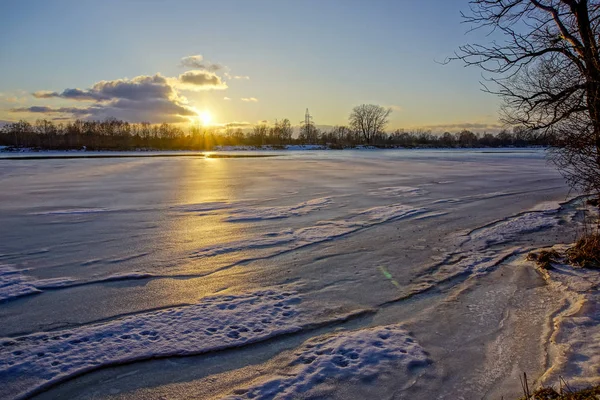 Барвистий зимовий захід сонця на замерзлому річковому льоду — стокове фото