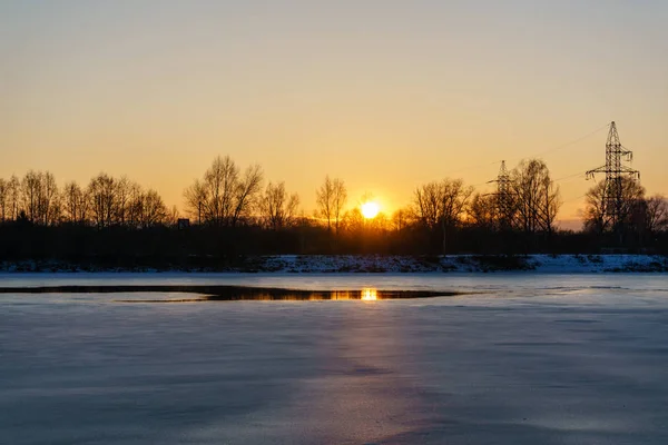 Pôr do sol de inverno colorido com árvores e linhas de energia no fundo — Fotografia de Stock