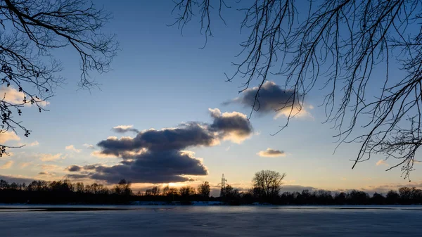Pôr do sol de inverno colorido no gelo congelado do rio — Fotografia de Stock