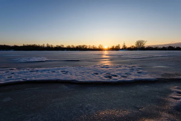 Colorful winter sunset on frozen river ice — Stock Photo, Image