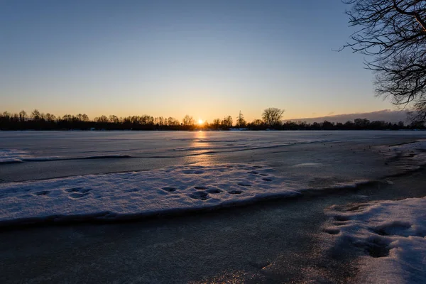 Zachód słońca zimą kolorowe na lodzie na zamarzniętej rzece — Zdjęcie stockowe