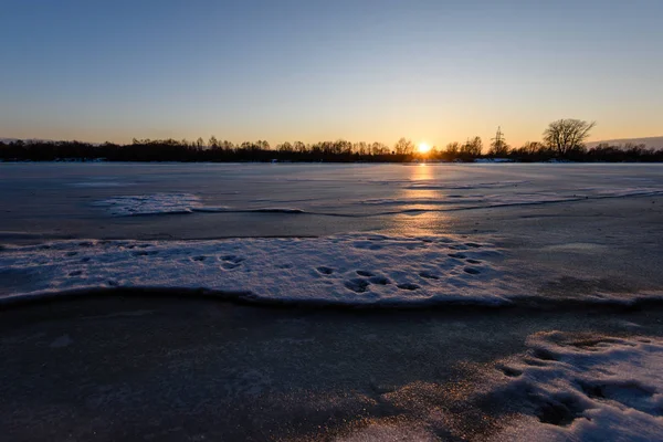 Colorful winter sunset on frozen river ice — Stock Photo, Image