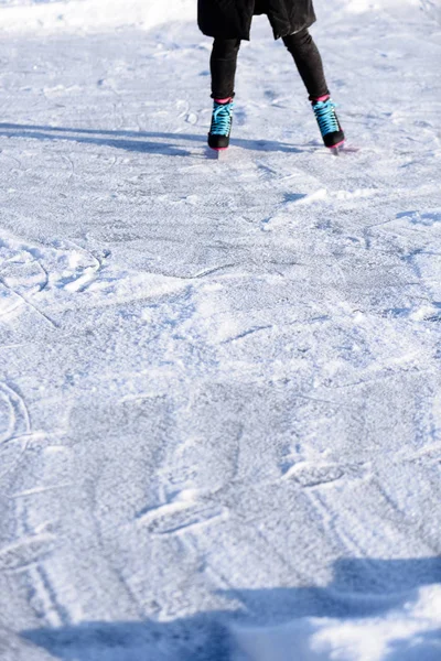 눈에 얼어붙은 호수에서 스케이트 검은 코트에 젊은 여자 — 스톡 사진