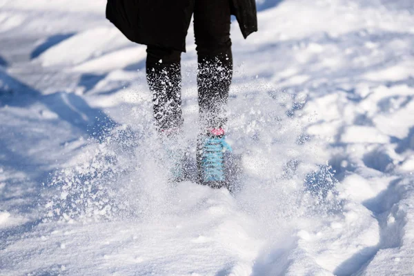 Fiatal nő fekete kabátot, korcsolyázás a befagyott tavon a hóban — Stock Fotó