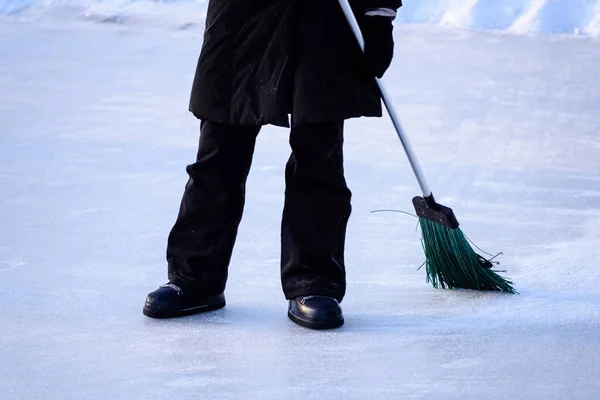 Giovane donna in cappotto nero pulizia ghiaccio dalla neve — Foto Stock