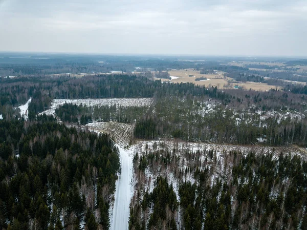 Imagem de drone. vista aérea da zona rural com estrada florestal em winte — Fotografia de Stock