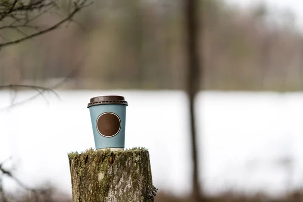 Tazza di caffè sul vecchio albero truunk nella foresta in inverno — Foto Stock