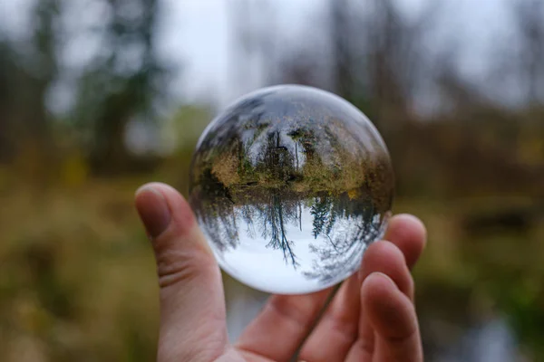 Maschio mano in possesso di sfera di vetro di cristallo sullo sfondo della natura w — Foto Stock
