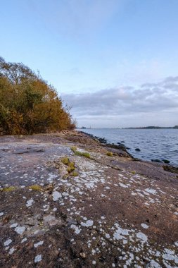 Kumlu donmuş deniz plajı ve bulutlu bir günde ilk kar.