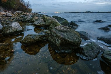 Riga 'nın endüstriyel limanı üzerinde gece bulutları ve ışıklar.