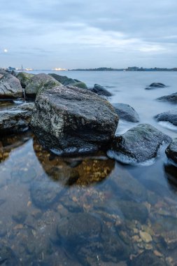 Riga 'nın endüstriyel limanı üzerinde gece bulutları ve ışıklar.