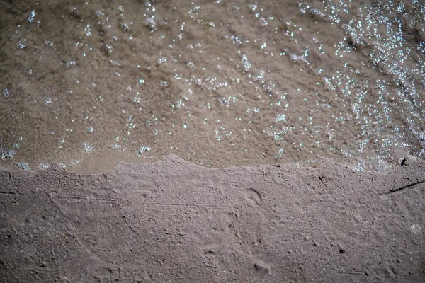 Plage de mer gelée avec sable et première neige par temps nuageux — Photo