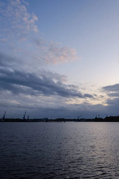 Nuages de nuit et lumières au-dessus du port industriel de la ville Riga à La — Photo