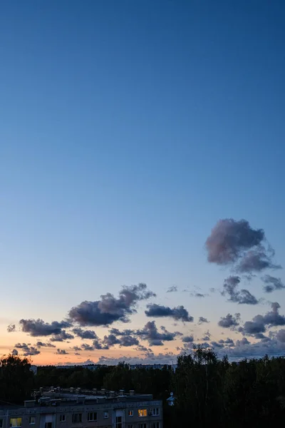 Яскраві хмари на заході сонця над міськими дахами Риги. — стокове фото
