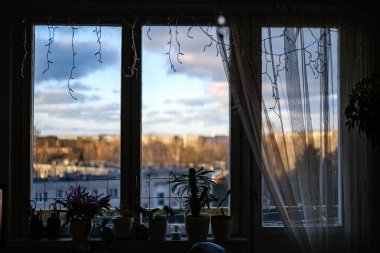 Sonbaharda apartman pencereleri, yılbaşı süsleri ve sokakta kış güneşi. sıkıcı tonlar