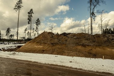 Kışın karlı ve çamurlu ormanda yeni bir yol inşaatı