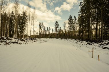 Kışın karlı ve çamurlu ormanda yeni bir yol inşaatı