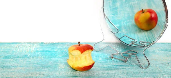 Bit of apple and reflection in a mirror of the whole apple — Stock Photo, Image