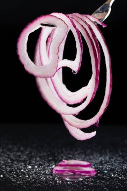 Siyah bir zemin üzerine mor soğan halkaları