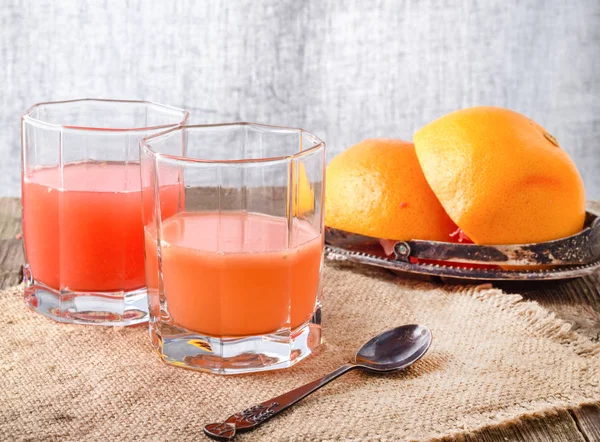 鲜榨的果汁的葡萄柚和它的果实 — 图库照片