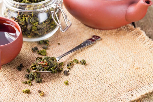 Trockene Blätter von grünem Tee im Glas — Stockfoto