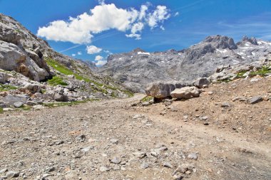Fuente De çevresinde taşlı parça Picos de Europa ve turistler, dağlarda. Güneşli bir gün, taş taluses, mavi gökyüzünde uçak izlemeler