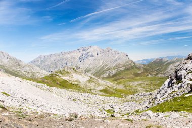 Fuente De çevresinde taşlı parça Picos de Europa ve turistler, dağlarda. Güneşli bir gün, taş taluses, mavi gökyüzünde uçak izlemeler