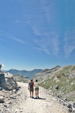 Fuente De, İspanya - 10 Temmuz 2016: Picos de Europa ve turistler, dağlarda taşlı parça Fuente De yakınında bulunmaktadır. Güneşli bir gün, taş taluses, mavi gökyüzünde uçak izlemeler
