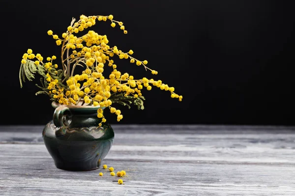 Egy-egy kerámia váza, a fekete háttérb mimóza sárga virágok — Stock Fotó