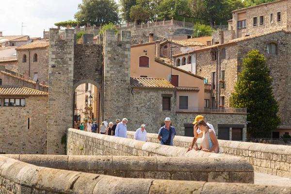 Besalu, spanien - 2. August 2019: Touristen auf einer Steinbrücke vor dem Eingang zu besalu. — Stockfoto