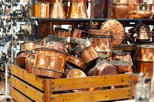 Oude gereinigde koperen gebruiksvoorwerpen opgestapeld in een houten doos in een winkel. — Stockfoto